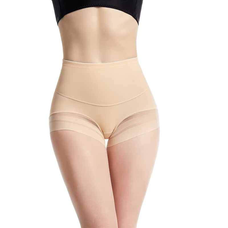 Femme portant une culotte mi-haute gainante couleur beige, avec finitions en tulle transparent autour des cuisses. Le mannequin est photographié de face, sur fond blanc, mettant en valeur la coupe lissante et le maintien de la taille.